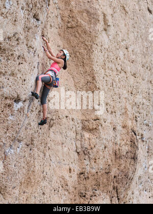 Mixed Race girl escalade falaise Banque D'Images