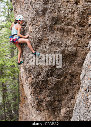 Mixed Race girl escalade falaise Banque D'Images