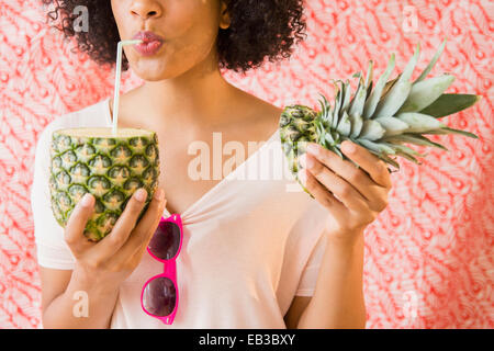 Femme boire du jus d'ananas frais Banque D'Images