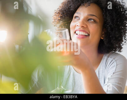 Smiling woman drinking glass of wine Banque D'Images