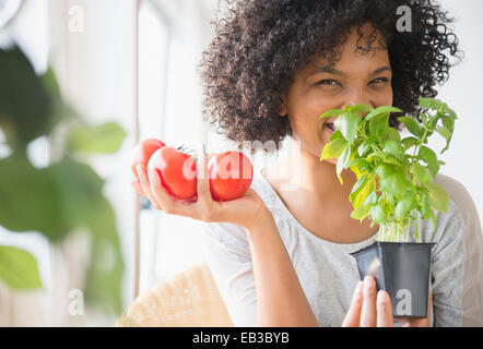 Femme souriante avec des plantes odorantes tomates Banque D'Images