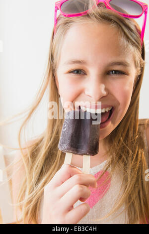 Caucasian girl eating popsicle raisin Banque D'Images