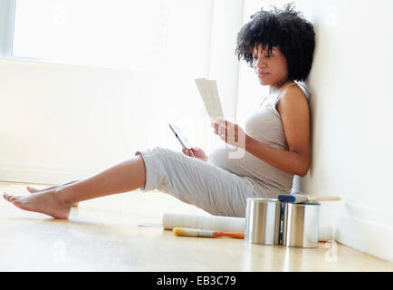 Pregnant African American mother examinant des échantillons de peinture pour pépinière Banque D'Images