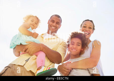 Low angle view of family smiling together outdoors Banque D'Images