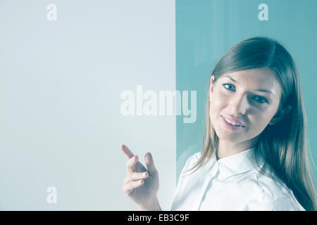 Smiling Businesswoman standing in front of ship dans la salle de conférence Banque D'Images