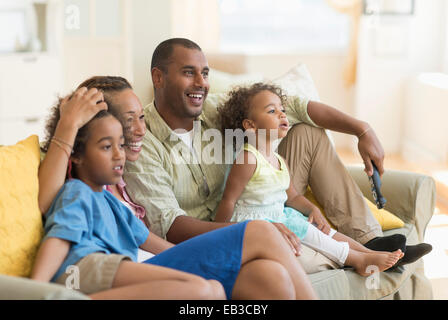 Famille regardent la télévision ensemble dans la salle de séjour Banque D'Images