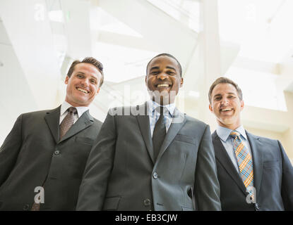 Low angle view of businessmen smiling in office Banque D'Images