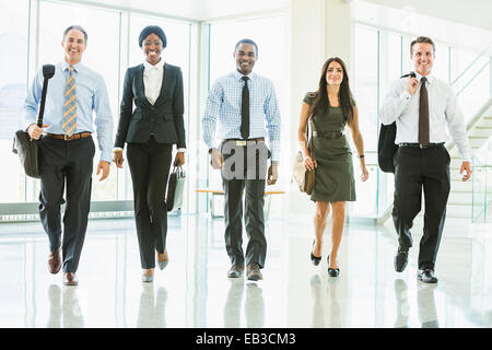 Business people walking in office lobby Banque D'Images