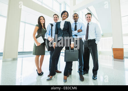 Business people smiling in office lobby Banque D'Images