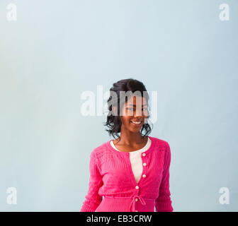 Studio portrait of mid adult woman wearing cardigan rose Banque D'Images