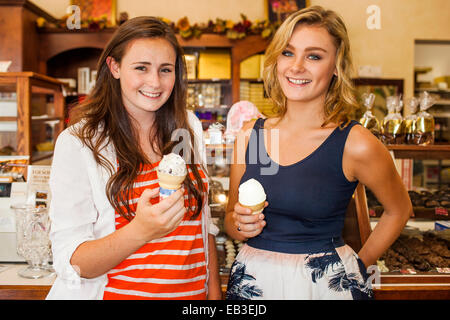 Caucasian teenage girls eating ice cream dans candy shop Banque D'Images