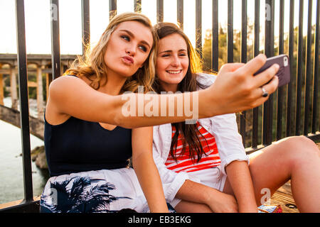 Caucasian teenage girls prendre des autoportraits de téléphone cellulaire Banque D'Images