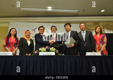 Kuala Lumpur, Malaisie. 25Th Nov, 2014. Des représentants une poignée de main après la signature d'un accord à Kuala Lumpur, Malaisie, le 25 novembre 2014. Cn Chine Changchun Véhicules ferroviaires Co., Ltd (CRC) a signé ce mardi un accord avec la Malaisie's Express Rail Link Sdn. Bhd. (ERL) pour la fourniture de six ensembles de trains à quatre voitures à la ligne du centre-ville de Kuala Lumpur à l'Aéroport International de Kuala Lumpur. © Chong Chung Voon/Xinhua/Alamy Live News Banque D'Images