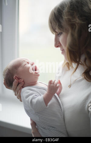 Jeune maman avec bébé qui pleure Banque D'Images