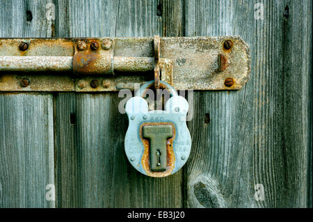 Cadenas ANCIENS EN MÉTAL LE VERROUILLAGE D'UN ANCIENNE VIS SUR UNE PORTE EN BOIS Banque D'Images