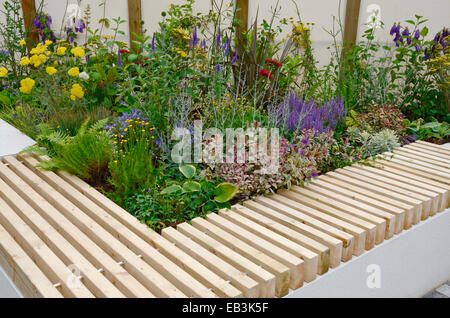 Une fleur frontière avec banc dans un jardin public de l'espace urbain Banque D'Images