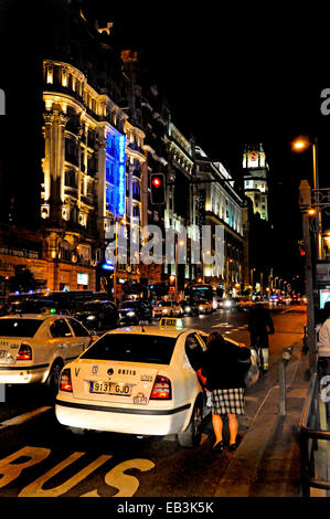 Madrid, Espagne. Femme d'entrer dans un taxi jusqu'à tard dans la nuit. Banque D'Images