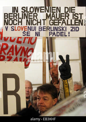 Ljubljana, Slovénie. 25Th Nov, 2014. Les personnes qui font preuve de leur politique du gouvernement devant le Grand Hotel Union européenne à Ljubljana, Slovénie, 25 novembre 2014. Un écriteau indique 'Le Mur de Berlin n'a pas baissé en Slovénie." Le Président allemand Gauck et Pahor Président slovène prennent part à une série de discussions dans l'immeuble. Le président allemand est sur une visite de deux jours en Slovénie. Photo : WOLFGANG KUMM/dpa/Alamy Live News Banque D'Images