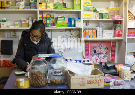 Commerçant chinois femelle faire livres en magasin dans le quartier chinois de nuit-Victoria, Colombie-Britannique, Canada. Banque D'Images