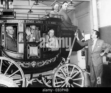 Les fonctionnaires du comté d'Orange County, y compris les superviseurs Willard Smith (à gauche) et Willis Warner (droite) posent dans un stage coach aux côtés de Walt Disney (extrême droite) à Disney Studios Décembre 1954 à Burbank, Californie. Walt Disney a invité des fonctionnaires du comté d'Orange à son studio à discuter de ses plans pour la création de Disneyland. Banque D'Images