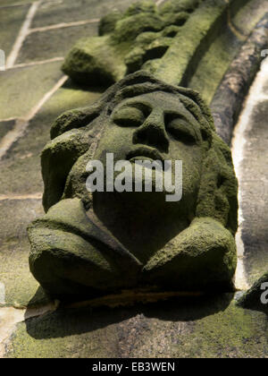 Une tête sculptée en pierre autour de la porte d'une église à Heptonstall Yorkshire. Banque D'Images