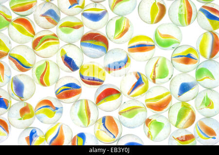 Un groupe de petites billes de verre illuminé sur un fond blanc. Banque D'Images