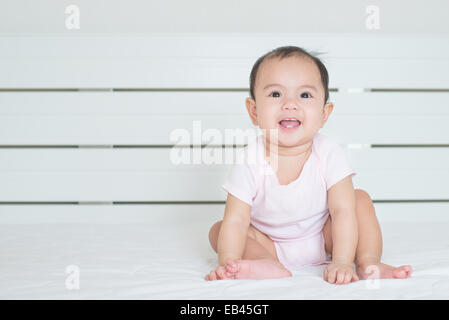 Cute asiatique fille bébé sourit dans la chambre Banque D'Images