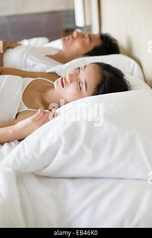 Jeune couple sleeping on bed Banque D'Images