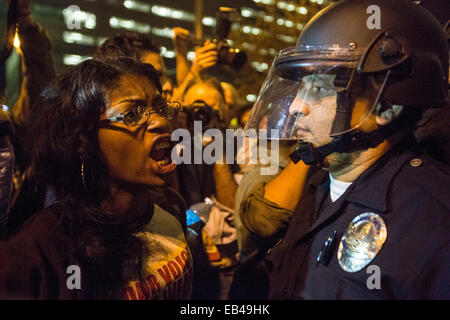 Los Angeles, USA. 25Th Nov, 2014. Un manifestant est confronté à un agent de police en face de l'administration centrale du ministère de la police de Los Angeles au cours d'une manifestation à Los Angeles, États-Unis, le 25 novembre 2014. Des milliers de personnes à Washington, New York, Boston et d'une douzaine d'autres villes à travers les États-Unis le mardi suite manifestations contre la décision prise lundi par un grand jury local du Missouri de ne pas inculper un officier de police blanc dans la mort d'un des jeunes Afro-Américains. Credit : Zhao Hanrong/Xinhua/Alamy Live News Banque D'Images