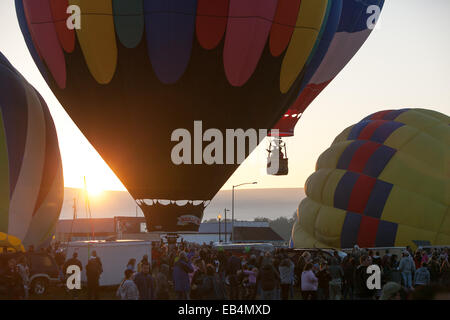 Au lever du soleil, plusieurs montgolfières décoller comme d'autres l'gonfler près d'une foule à l'Prosser Balloon Rally. Banque D'Images