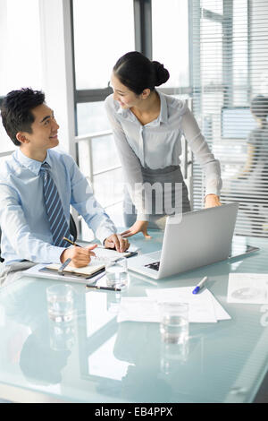 Young businesswoman and businessman talking in office Banque D'Images