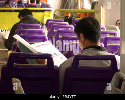 Chine Hong Kong Cheung Chau homme lire Journal en ferry Banque D'Images