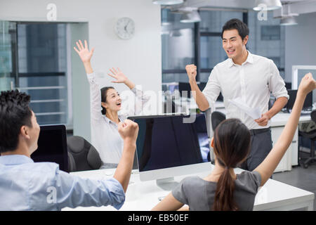 Les jeunes gens d'affaires cheering in office Banque D'Images