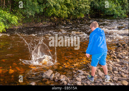 Un enfant joue sur la rivière Swale à Swaledale dans le Yorkshire Dales dans le Yorkshire , Angleterre , Angleterre , Royaume-Uni Banque D'Images