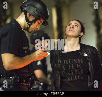 Los Angeles, Californie, USA. 25Th Nov, 2014. Une jeune femme, l'une des premières demi-douzaine d'être arrêté le mercredi ressemble le ciel comme un agent de police de Los Angeles a terminé la paperasse avant qu'elle est transportée à la prison de la ville.--- Le mardi soir a vu la poursuite des manifestations à Los Angeles alors que les manifestants se sont mobilisés contre le Grand Jury Ferguson et leur décision de ne pas inculper officer Darren Wilson à la suite de son implication dans le tournage Michael Brown au début du mois d'août de cette année. Tôt mercredi matin a vu l'arrestation de plusieurs dizaines de manifestants le soupçon de conduite désordonnée. Le LAPD dans la boîte Banque D'Images