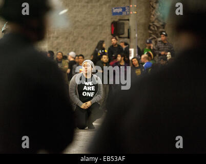 Los Angeles, Californie, USA. 25Th Nov, 2014. Une jeune femme s'agenouille alors qu'elle attend d'être placés dans des menottes et entraînés pour le transport vers la prison de la ville, mercredi matin. --- Mardi soir a vu la poursuite des manifestations à Los Angeles alors que les manifestants se sont mobilisés contre le Grand Jury Ferguson et leur décision de ne pas inculper officer Darren Wilson à la suite de son implication dans le tournage Michael Brown au début du mois d'août de cette année. Tôt mercredi matin a vu l'arrestation de plusieurs dizaines de manifestants le soupçon de conduite désordonnée. Le LAPD dans en boîte les manifestants à l'intersection de Temple et Banque D'Images