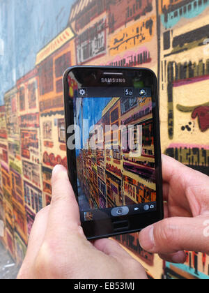 Chine Hong Kong man with smartphone Samsung graffiti peinture murale Banque D'Images