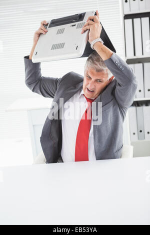 Angry businessman throwing son ordinateur portable Banque D'Images