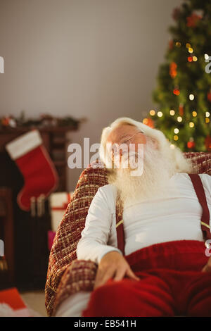 Santa Claus en appui sur le fauteuil Banque D'Images