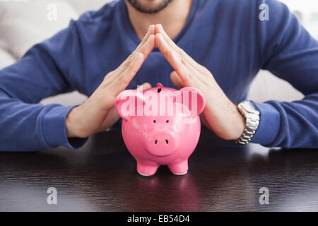 Jeune homme à la tirelire Banque D'Images