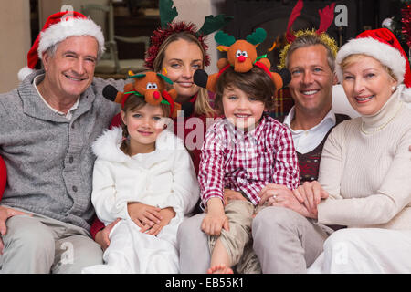 Famille multigénérationnelle wearing santa hats sur canapé Banque D'Images