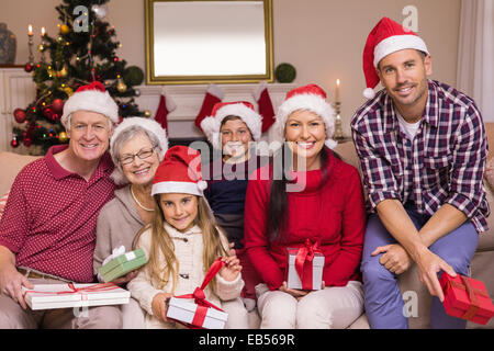 Famille multigénérationnelle wearing santa hats sur canapé Banque D'Images