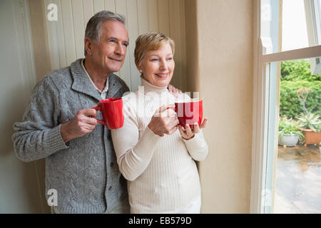 Senior couple holding mugs rouge Banque D'Images