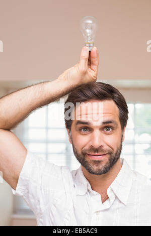 Man holding ampoule au-dessus de sa tête Banque D'Images