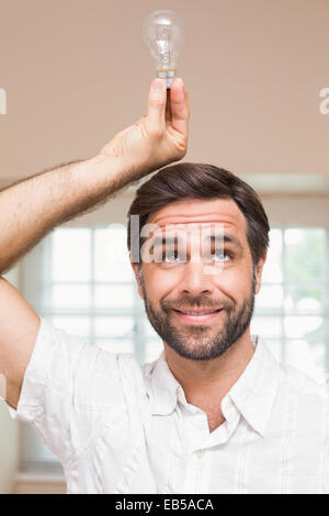 Man holding ampoule au-dessus de sa tête Banque D'Images