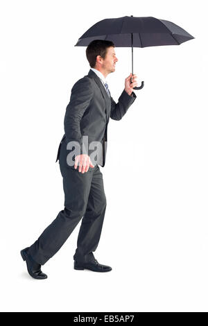Businessman s'abritant sous parapluie noir Banque D'Images