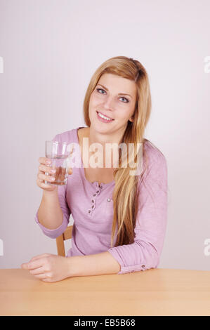 Young woman holding glass of water Banque D'Images