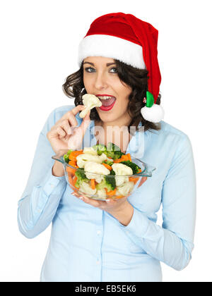 Young woman in christmas santa hat holding bol de légumes mixtes Banque D'Images