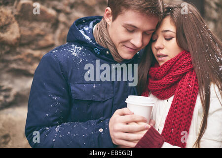 Couple romantique réchauffe avec du café à l'extérieur Banque D'Images