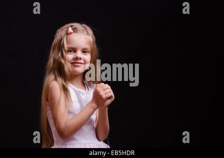 Portrait d'une belle petite fille de cinq ans sur un fond noir Banque D'Images